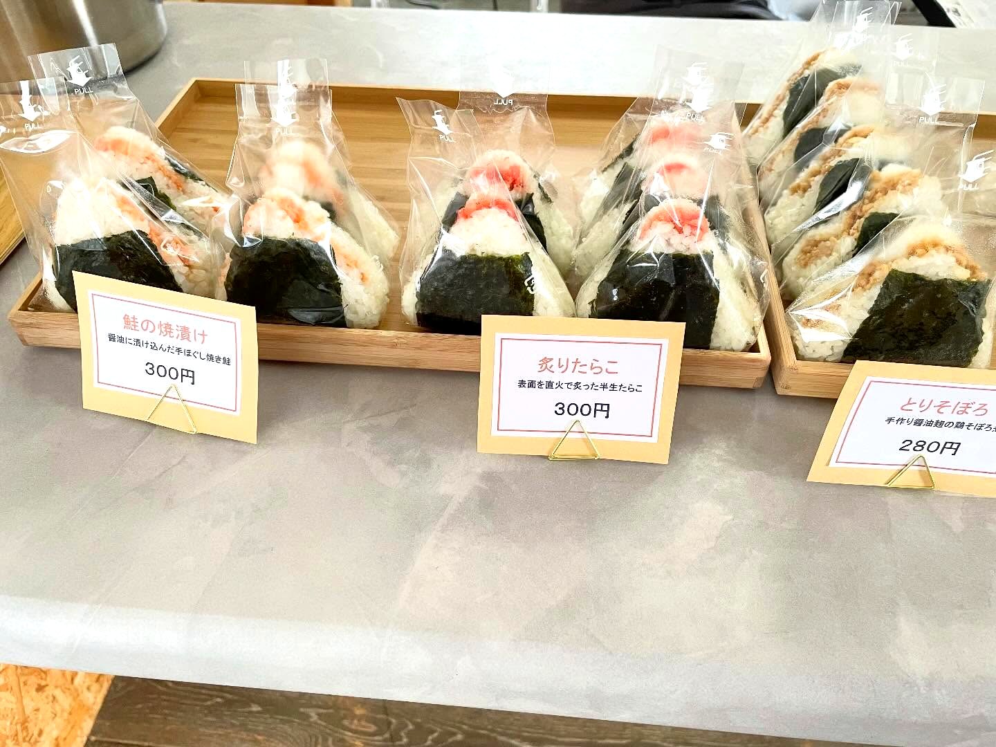 種類ごとに札を添えて並ぶ包装済みのおむすび